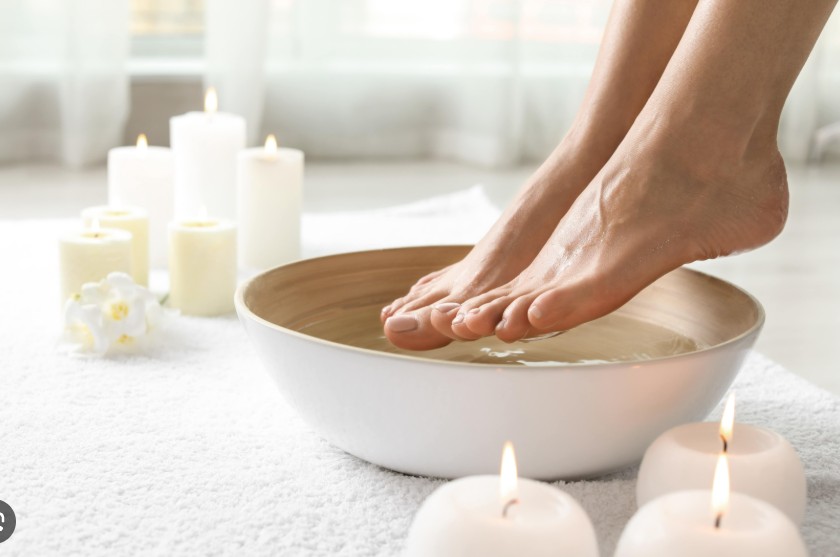 Pés em bacia com ervas naturais e velas